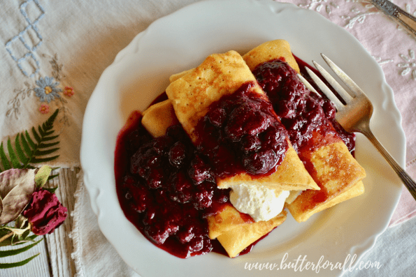 A lovely plate of fresh blintzes smothered in warm mixed berry compote.