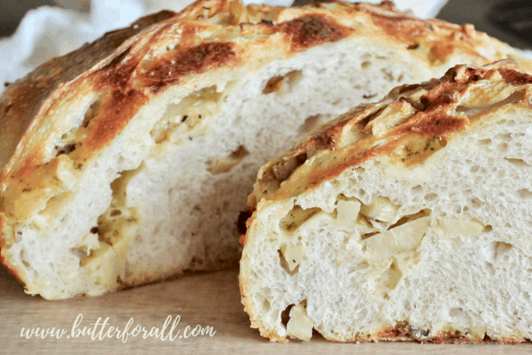 Sliced cheesy sourdough pizza bread showing the roasted artichokes and melted cheese within.