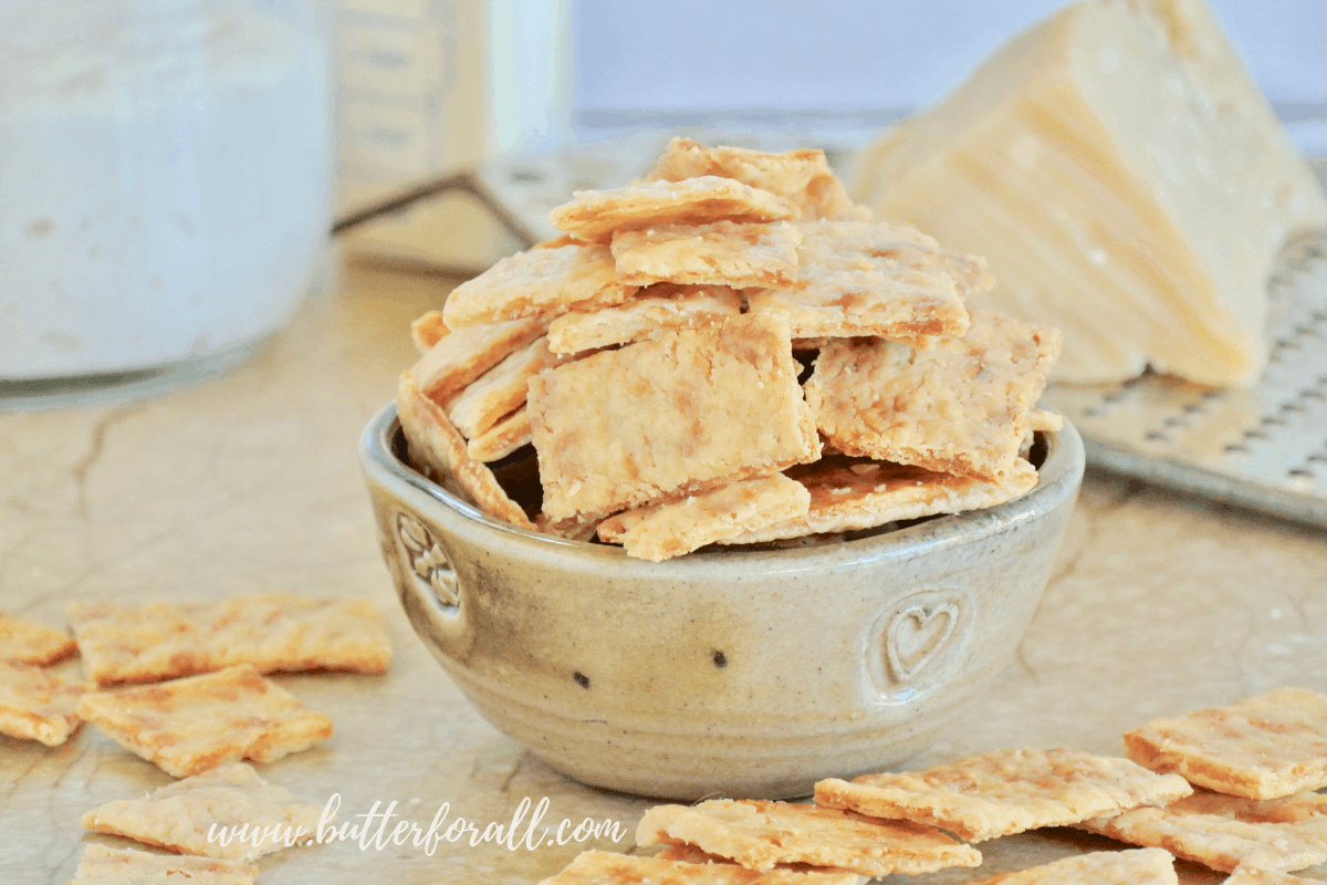 A bowl of these super crispy and crunchy Buttery Parmesan Sourdough Discard Crackers makes an excellent homemade snack. #starter #sourdough #wildyeast #fermented #realfood #wisetraditions #crackers #cheesecrackers #healthysnacks #easy #crunchysnacks