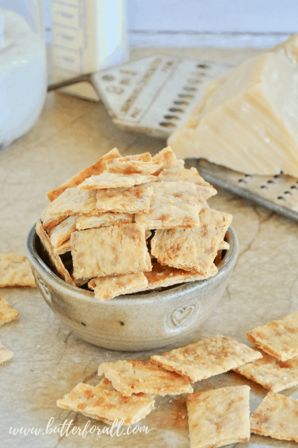 A large bowl of the crispiest, cheesiest, sourdough discard crackers made with real butter, real Parmesan and fully fermented sourdough discard! #starter #sourdough #wildyeast #fermented #realfood #wisetraditions #crackers #cheesecrackers #healthysnacks #easy #crunchysnacks