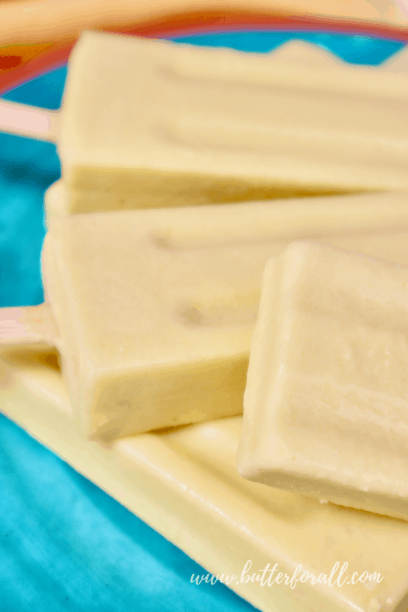 A close-up of frosty coconut mango lassi popsicles.
