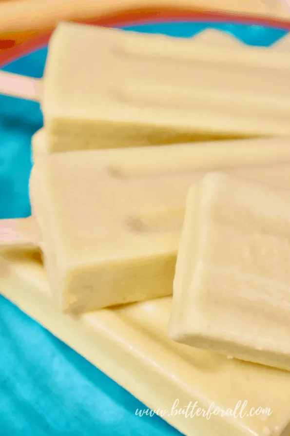 A close-up of frosty coconut mango lassi popsicles.
