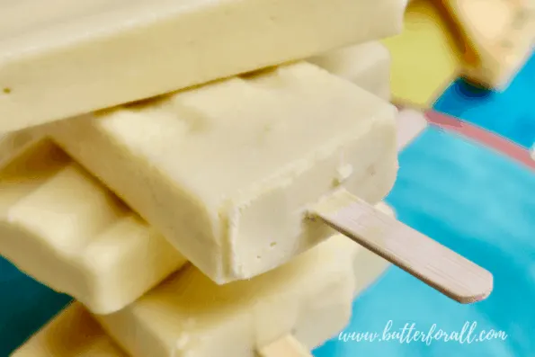 Close-up of frosty coconut mango lassi popsicles.