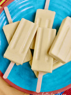 A colorful plate of frosty probiotic coconut mango lassi popsicles.