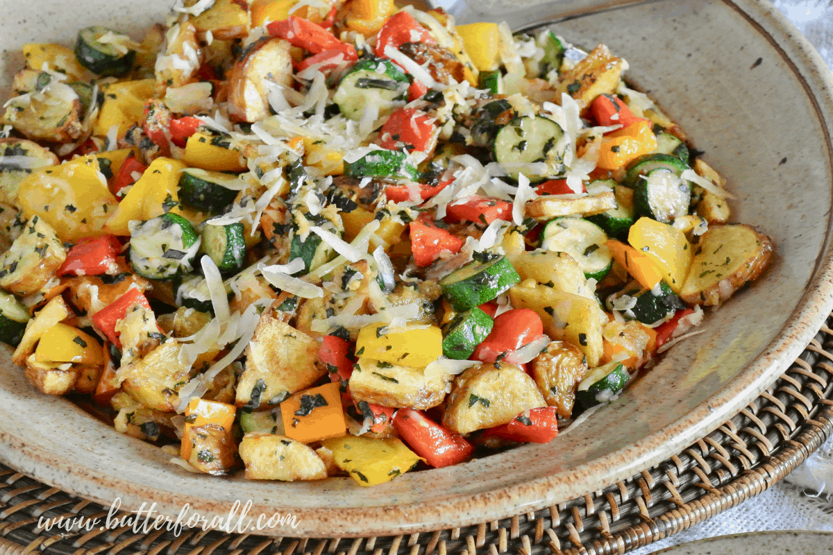 A perfect platter of Sheet-Pan Roasted Vegetables garnished with fresh Parmesan cheese and basil makes an easy and impressive side dish busting with color and flavor! #realfood #onepan #easy #summer #potluck #potatoes #squash #peppers #herbs #parmesan #basil #sidedish #entertaining