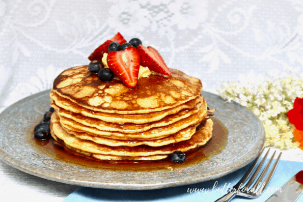 A plate of sourdough pancakes with syrup and fresh berries.