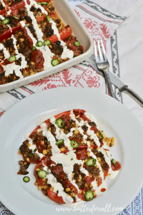 A plate of baked stuffed peppers with sauce.