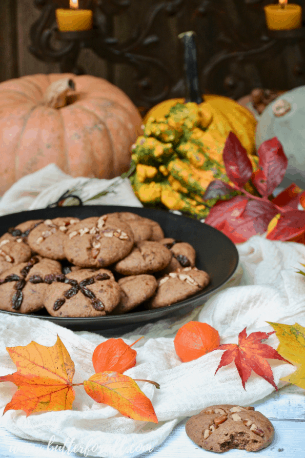 A plate of soul cakes on a table with fall decor.