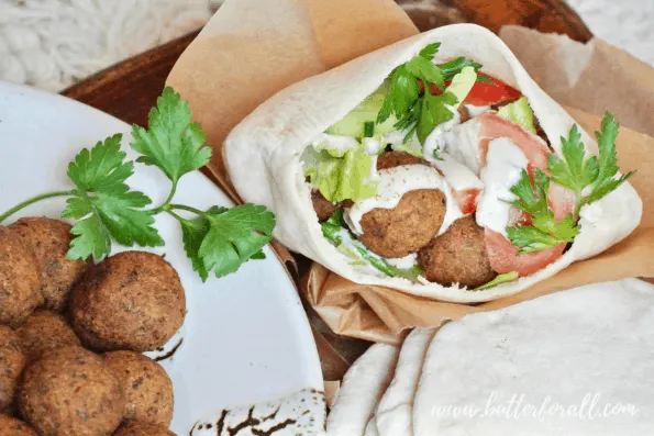 Pita bread overflowing with falafel fillings.