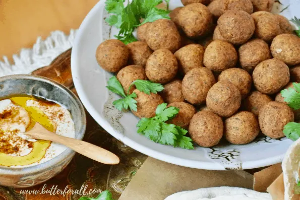 A bowl of falafel balls with tahini.