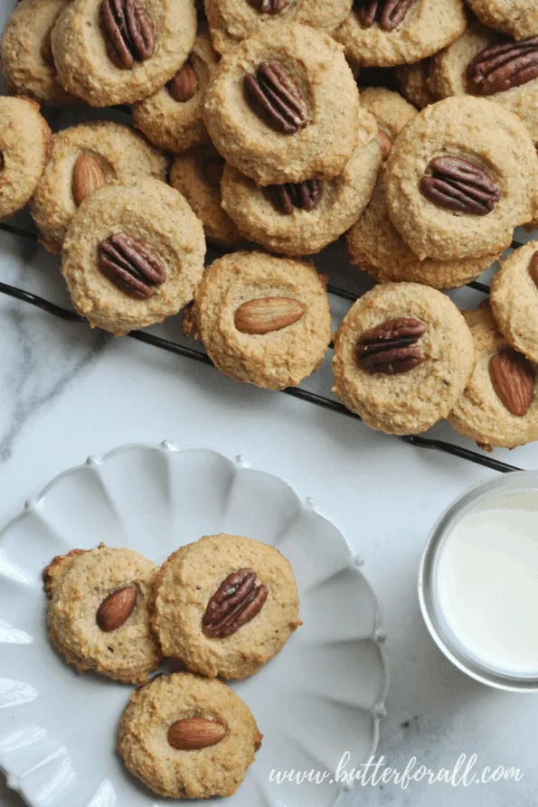 A plate of grain-free cookies topped with pecans.