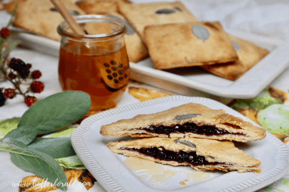 A plate with a perfectly brown toaster tart cut in half and showing the delicious blackberry filling.