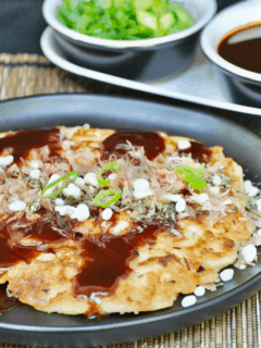 Perfectly cooked Okonomiyaki pancake with toppings and sauce.