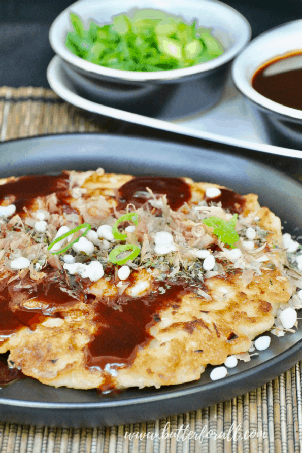 Perfectly cooked okonomiyaki pancake with toppings and sauce.
