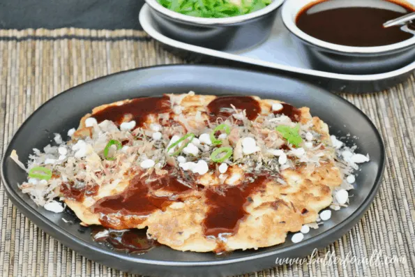 Golden brown sourdough okonomiyaki topped with sauce and seaweed.