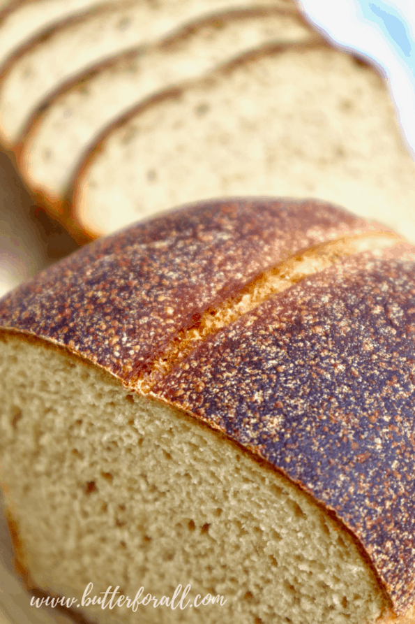 The golden-brown crust of a freshly baked loaf of Kamut sourdough sandwich bread.