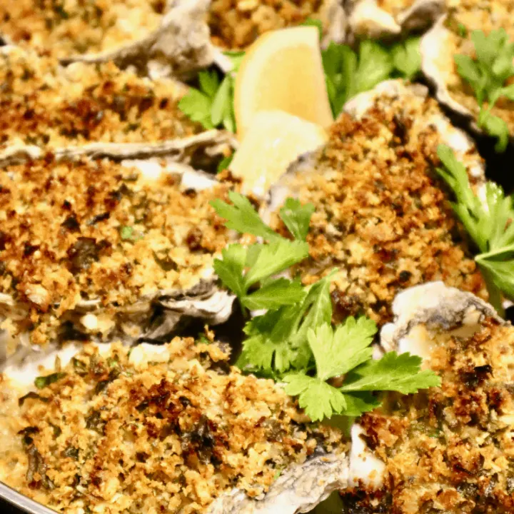 A baking pan displaying freshly baked oysters with sourdough breadcrumb topping.