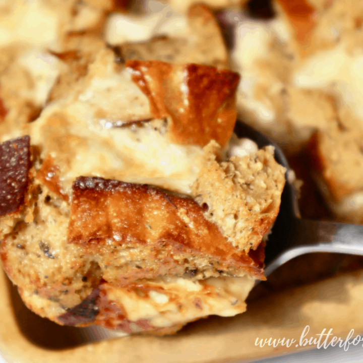 Scooping hot sourdough bread pudding from the pan.