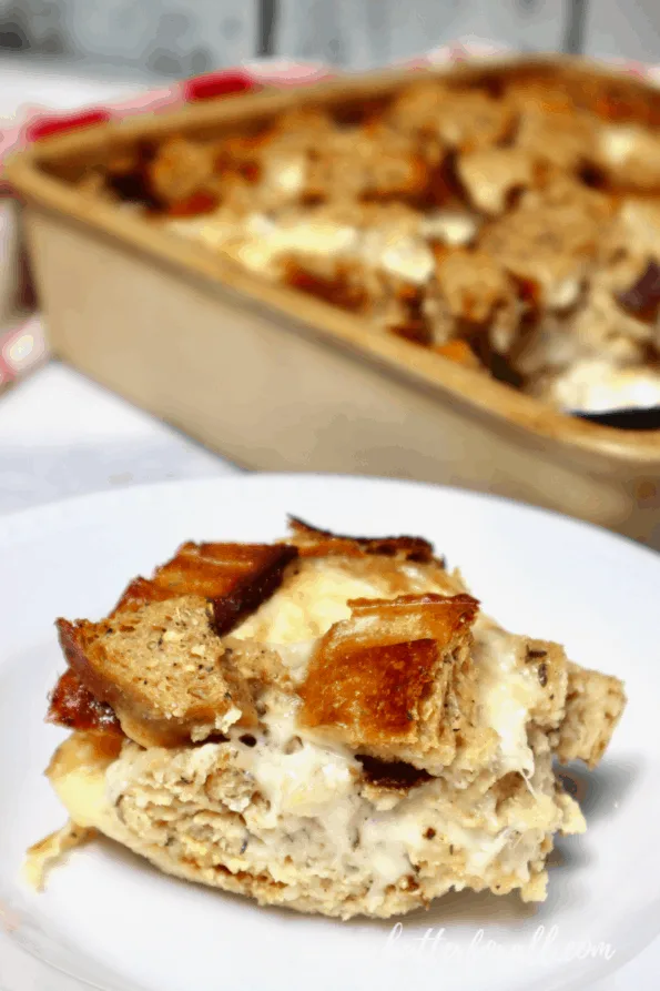 A serving of fresh sourdough bread pudding with casserole dish in the background.