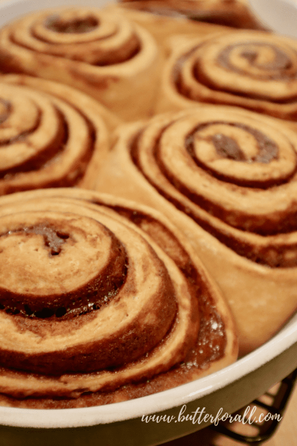 A pan of freshly baked cinnamon rolls with bubbling filling.