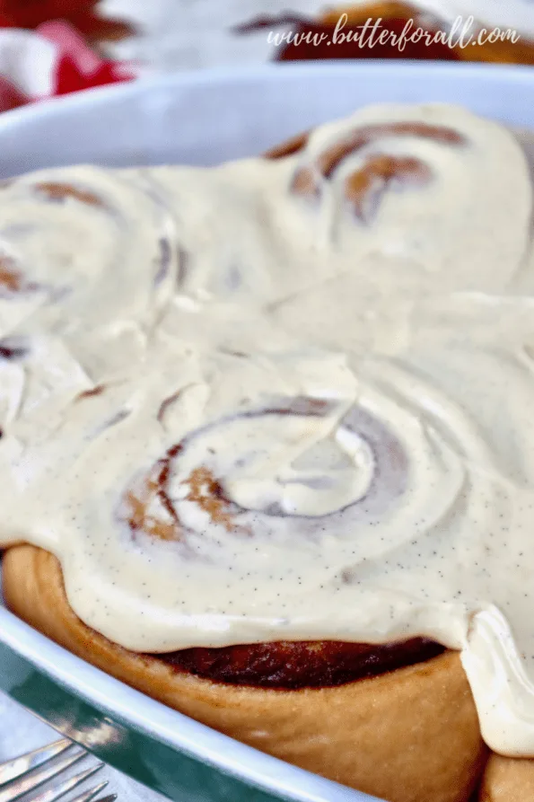 Close-up of cinnamon rolls loaded with vanilla cream cheese frosting.