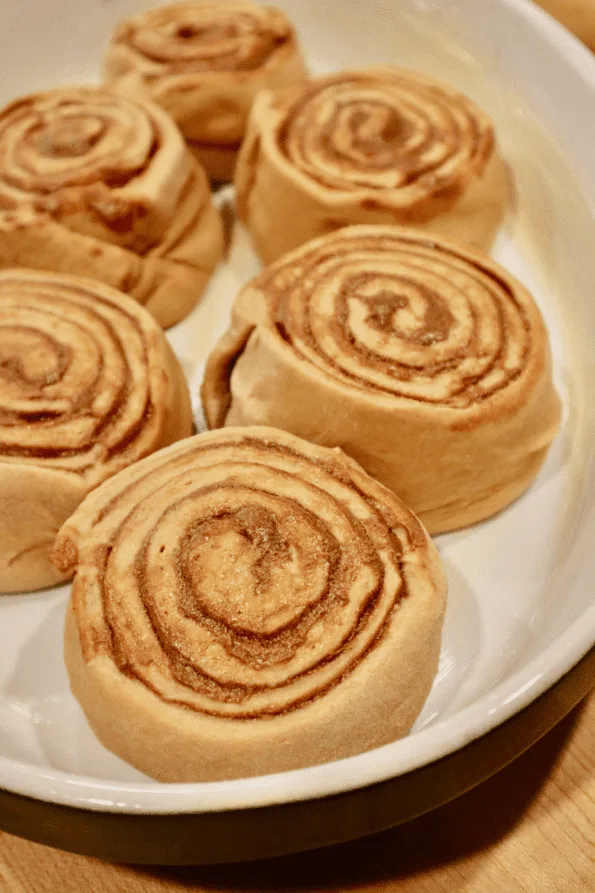 Raw cinnamon rolls placed in a pan for rising.