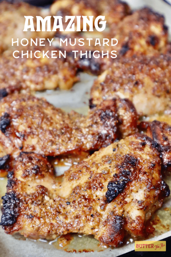 A sheet pan with golden brown and sticky roasted honey mustard chicken thighs.