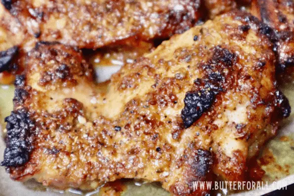 A close-up photo of sticky, golden-brown honey mustard chicken thighs.