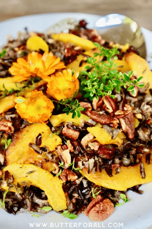 Close-up of the fluffy, black wild rice grains, golden delicata squash, juicy cranberries, toasted pecans, and fresh thyme.