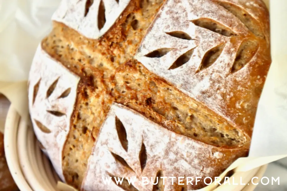 A crusty sourdough boule with beautiful scoring and a golden color. 