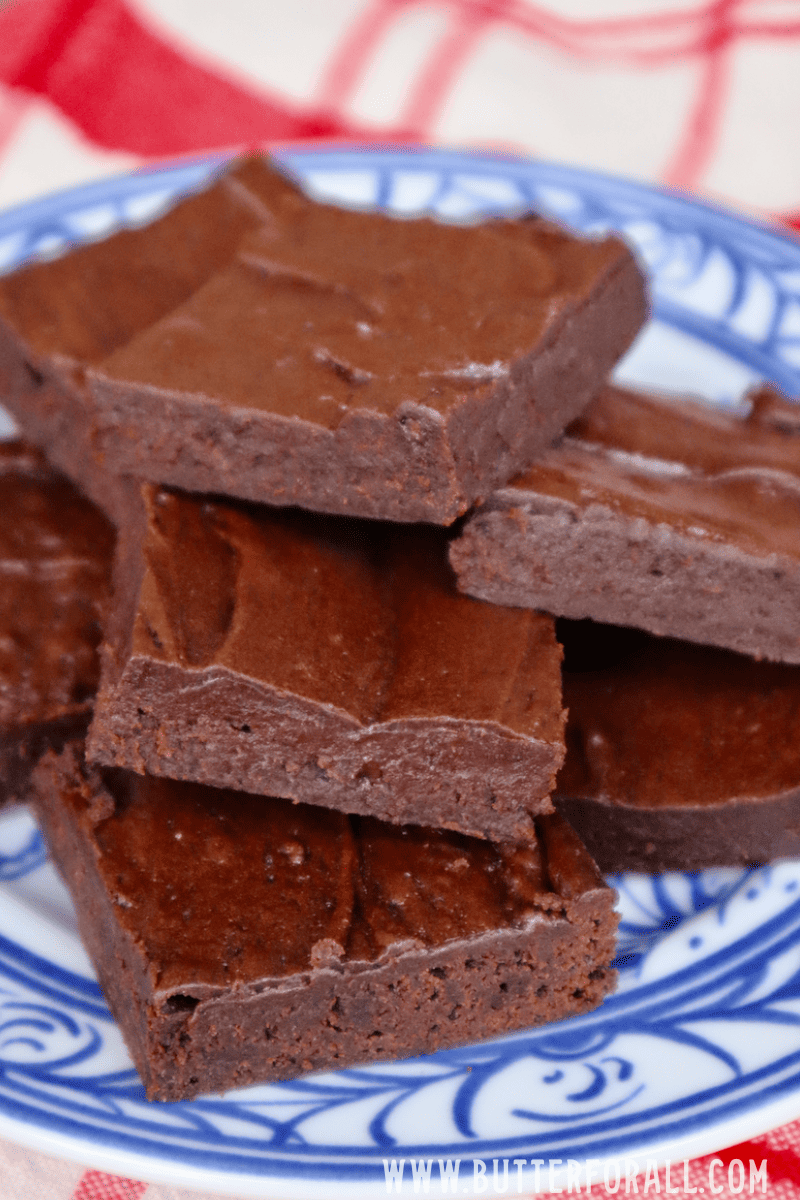 A plate full of fudgy brownies with crisp edges.