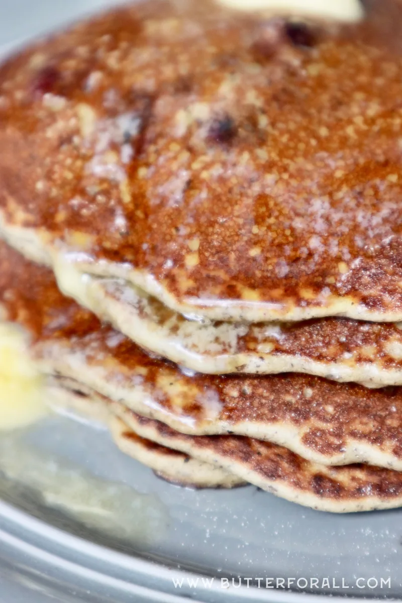 Nutrient-dense, gluten-free and golden-brown pancakes on a plate with melted butter.