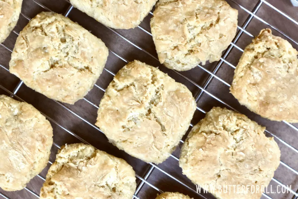 An overhead shot of golden brown sourdough biscuits on a cooling rack.